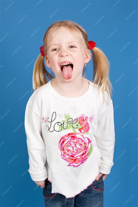 Premium Photo | Girl with hair in pigtails shows tongue