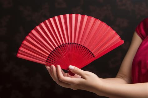 Premium Photo | Elegant red fan held in graceful hands