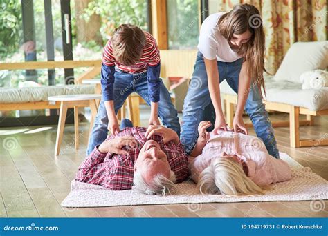 Two Sibling Kids Tickle Grandma and Grandpa Stock Image - Image of room 