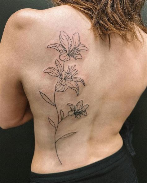 Fine line lily flowers tattooed on the back.