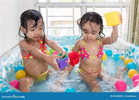 Happy Asian Chinese Little Sisters Playing in the Inflatable Poo Stock ...