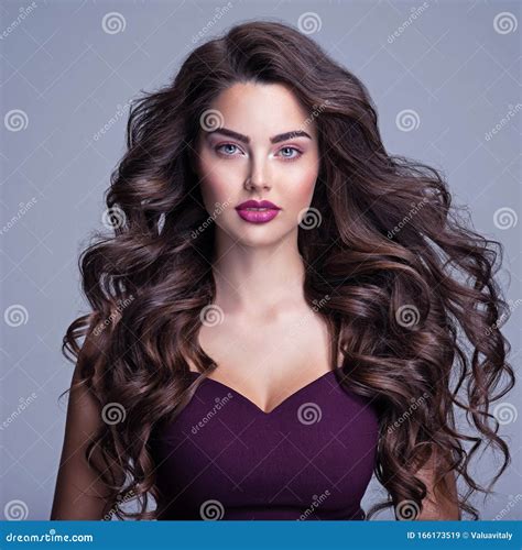 Face of a Beautiful Woman with Long Brown Curly Hair. Fashion Model