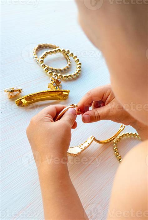 childrens hands play with gold jewelry and bijouterie, on white ...