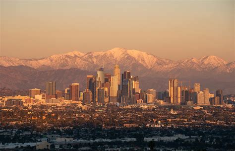 Golden Hour Los Angeles Skyline with Snowy MountainsFree Stock Photo