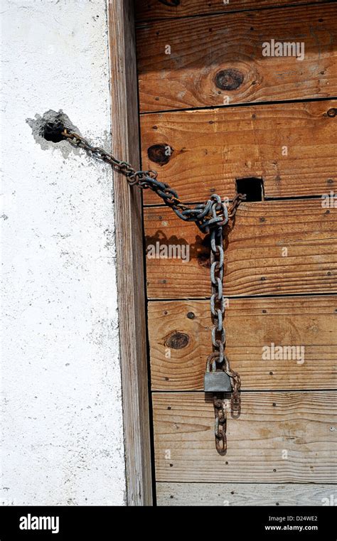 Wooden door locked with a chain and lock Stock Photo - Alamy