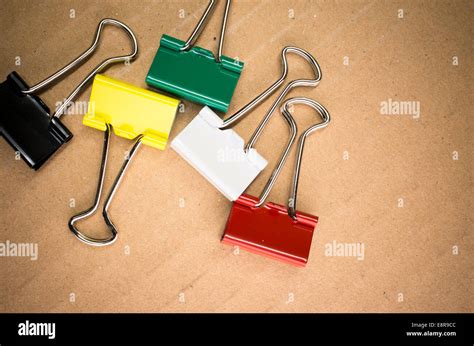colored metal paper clips on a cardboard background Stock Photo - Alamy