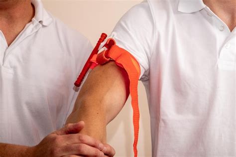 O Que É Um Torniquete - Um profissional de saúde demonstra como aplicar um torniquete no braço ...