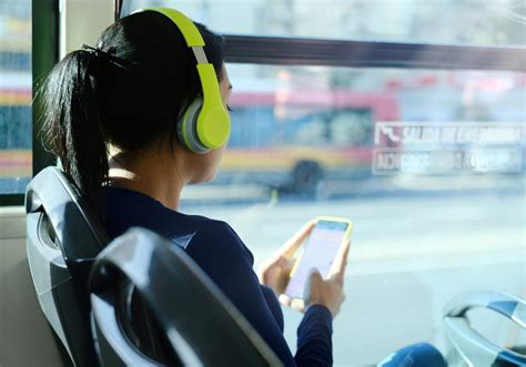 Woman With Headphones Listening To Music Commuting By Bus