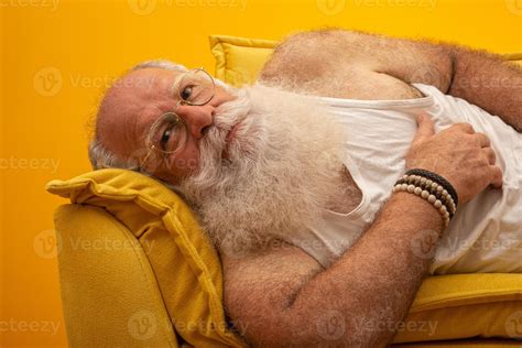Old man with a long beard on a yellow background. Senior with full