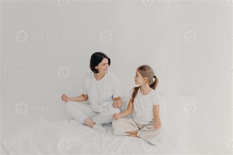 Indoor shot of happy mom and daughter have pleasant talk together, have