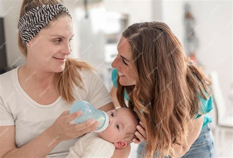 Premium Photo | A lesbian couple giving a bottle of milk to their baby
