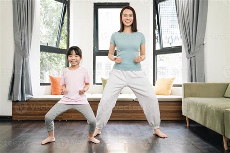Asian mother and daughter exercise at home 22495034 Stock Photo at Vecteezy