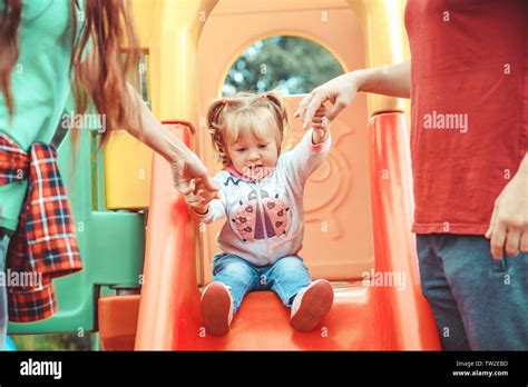 little girl rolling down the hill in the Park Stock Photo - Alamy