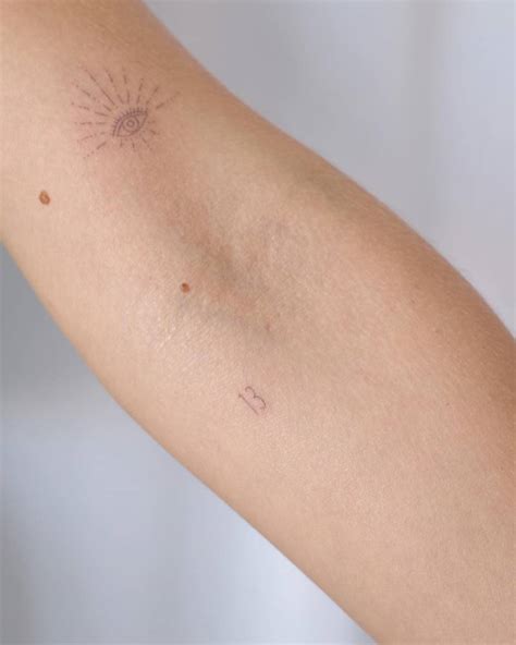 Fine line style evil eye and number "13" tattoos.