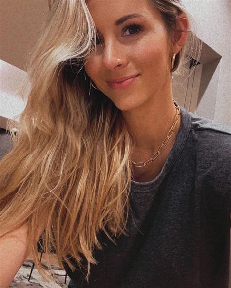 a woman with long blonde hair posing for a photo in front of a mirror ...