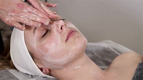 An experienced cosmetologist massage therapist performs a relaxing facial massage for the client