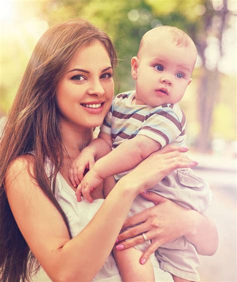 Baby in Park Outdoor. Kid with Toy on Mom`s Hands. Stock Photo - Image ...