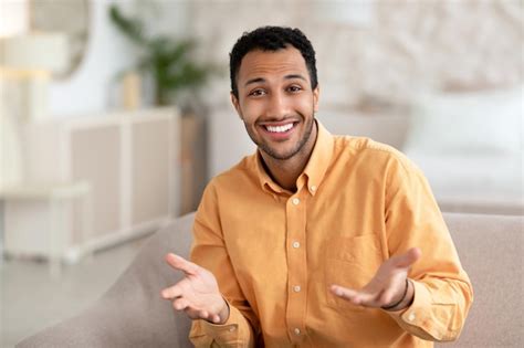 premium photo smiling young man talking  gesturing  camera