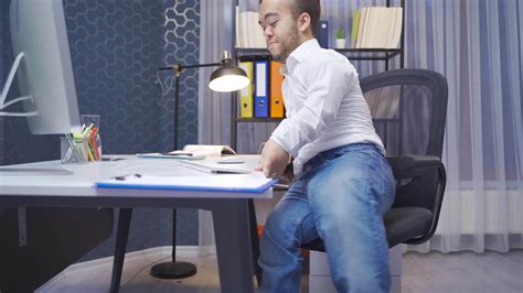 Disabled midget man sitting in his office looks at the camera and makes