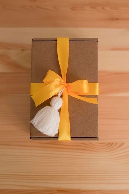 Premium Photo | Kraft box with yellow ribbon