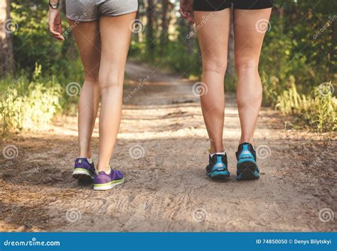 Молодые ноги девушки фитнеса на лесе отстают на заходе солнца Sporty ...