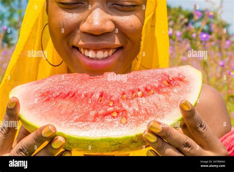 pretty young african lady enjoying a delicious slice of watermelon ...