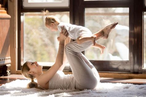 Young Attractive Yogi Mother and Baby Daughter Exercising at Hom Stock ...