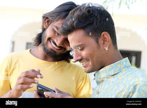 Happy young Indian gay couple looking at their photos on the phone