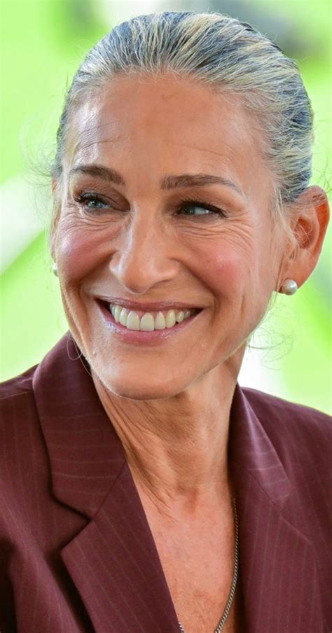 an older woman smiling and wearing a suit
