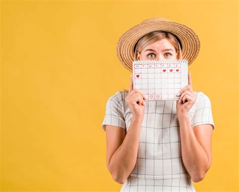 Free Photo | Woman looking up and holding menstruation calendar with