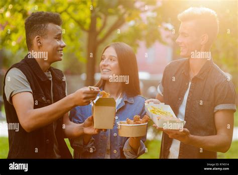 Young people eating and talking Stock Photo - Alamy