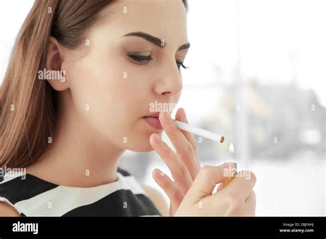 Young woman lighting cigarette at home Stock Photo - Alamy