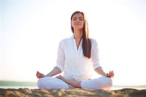 woman-sitting-by-the-ocean-with-beautiful-lighting-in-meditation ...