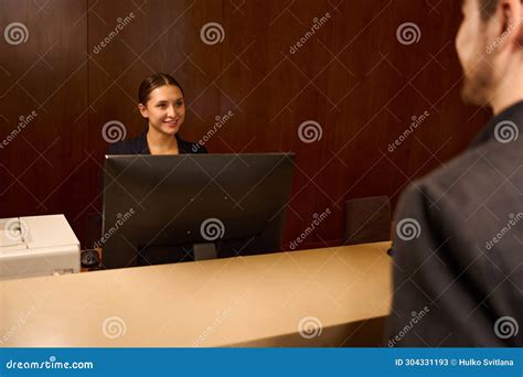 smiling woman receptionist welcoming visitor  hotel stock image