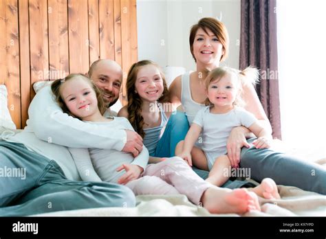 Young happy family of five on bedroom Stock Photo - Alamy