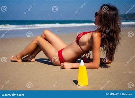 beautiful tanned female fitness big boobs model spf applying