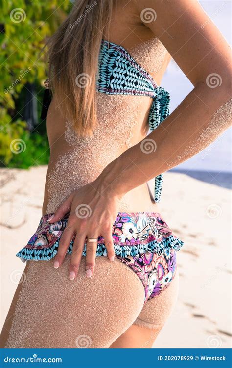 vertical shot   woman   bikini covered  sand   tropical