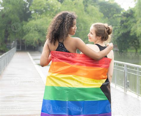 amistad de dos personas lesbianas con la bandera del orgullo del arco
