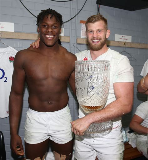 two men standing next to each other in front of a locker room holding a ...