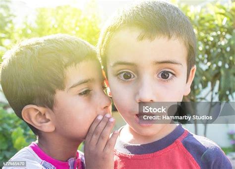 anak kecil berbisik  telinga temannya foto stok  gambar