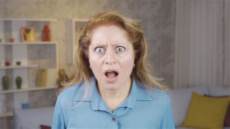 Mature woman is surprised. Sympathetic mature woman looks at camera and
