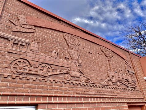 This brick train mural above the back entrance to a local jeweler : r