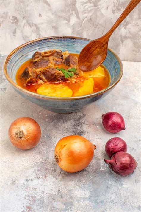 Free Photo | Front view bozbash soup in a bowl and onions on nude