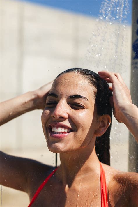 "Portrait Of A Young Woman Washing Under A Shower On The Beach." by