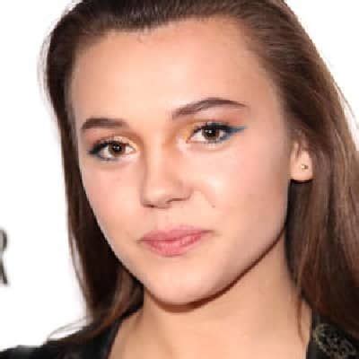 a close up of a person with long hair and blue eyeshadow wearing a ...