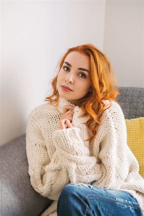 "Portrait Of Beautiful Redhead Woman Weraing White Sweater At Home" by