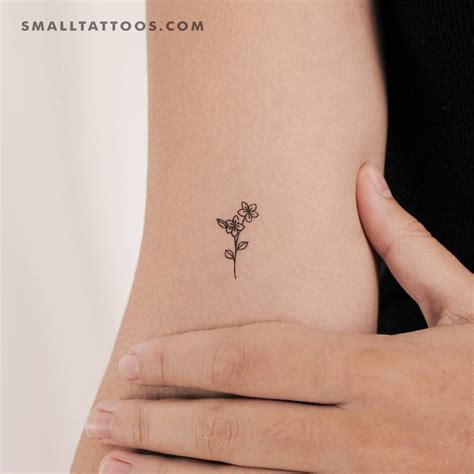 Tiny minimalistic flowers temporary tattoo located on