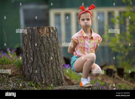 Little naughty girl makes faces at the camera while sitting near ...