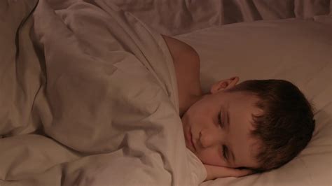 happy kid boy falls asleep in bed in the bedroom in the evening. Cute