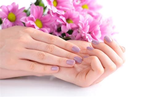Manos de una mujer con manicura rosa en las uñas y flores rosas. | Foto ...